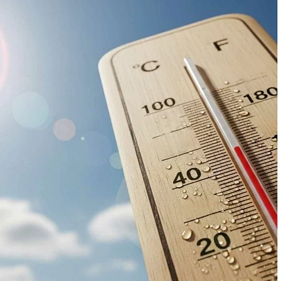 Ein Thermometer zeigt Temperaturen in Celsius und Fahrenheit an. Der Thermometerstrahl ist bei etwa 25 °C und 80 °F markiert. Im Hintergrund ist ein blauer Himmel mit einigen Wolken sichtbar.