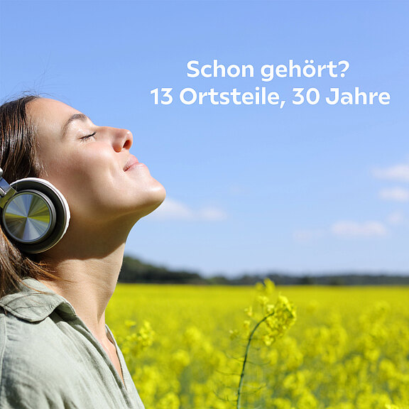 Eine Frau mit Kopfhörern, die entspannt nach oben blickt, steht vor einer gelben Blumenwiese. Der Text "Schon gehört? 13 Ortsteile, 30 Jahre" steht in der oberen Bildhälfte.