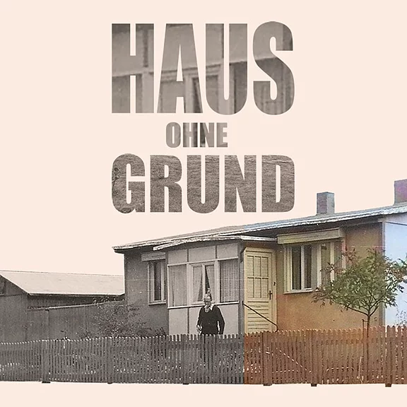 Großer Schriftzug „HAUS OHNE GRUND“ dominiert das Bild; darunter ein kleines, schlichtes Haus hinter Holzzaun, mit einer einzelnen Person am Eingang.