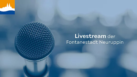 Nahaufnahme eines Mikrofons vor unscharfem Hintergrund. Schrift: „Livestream der Fontanestadt Neuruppin“ – Ankündigung eines städtischen Livestreams.