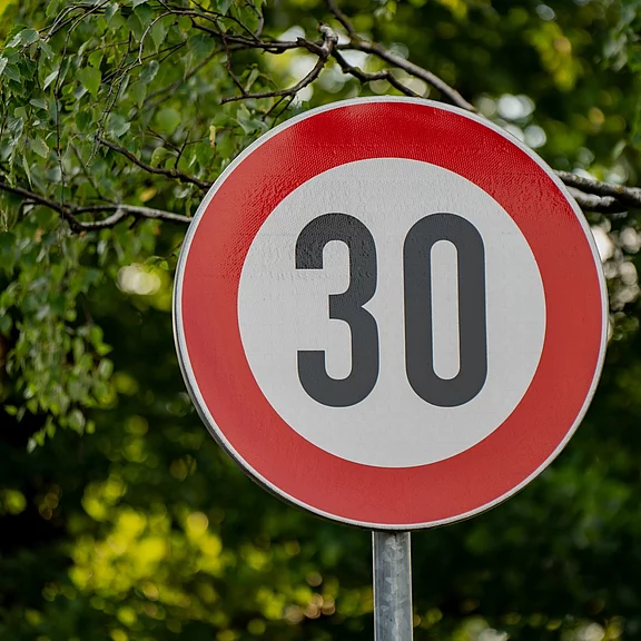 Rundes Verkehrsschild mit rotem Rand und schwarzer Zahl 30 auf weißem Grund, zeigt eine zulässige Höchstgeschwindigkeit von 30 km/h an.